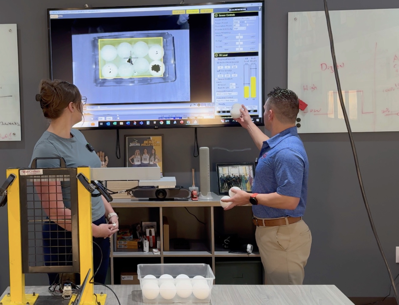 A technical team demonstrating an industrial machine-vision system
