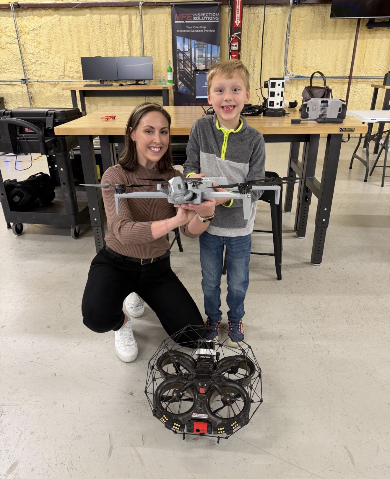 Jordan Yates and a young visitor holding an industrial inspection drone at MFE Inspection Solutions
