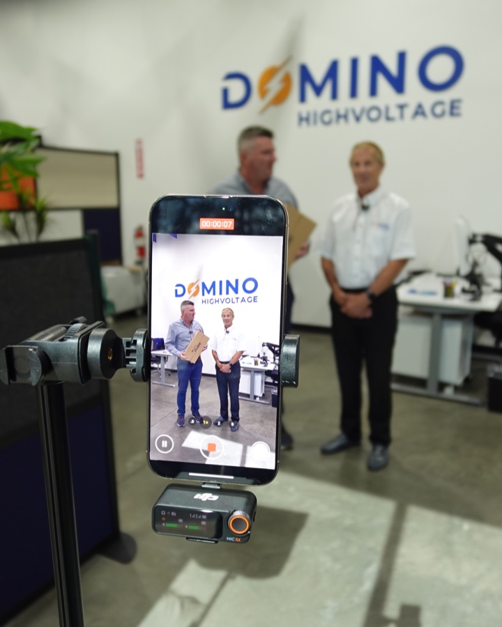 A smartphone recording two Domino Highvoltage team members during an on-site content shoot